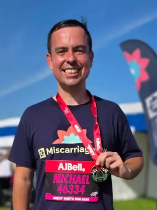 Michael Chambers smiling with his medal after finishing the Great North Run